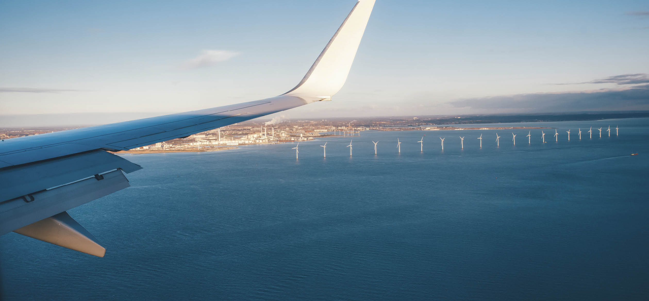 The plane approaching Copenhagen airport flying over sea full of windmill turbines.